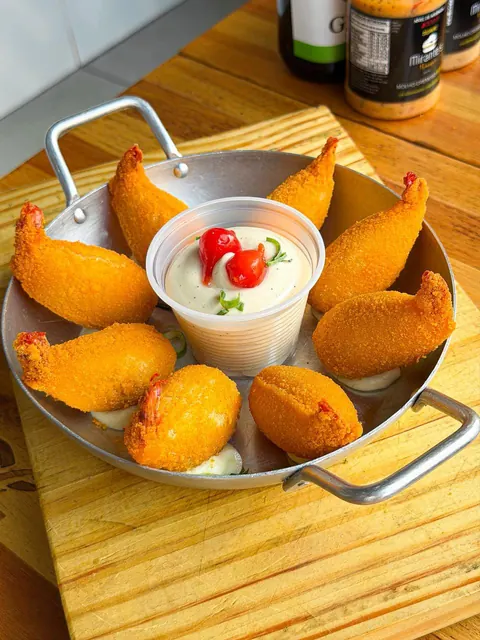Porção de coxinhas acompanhada de molho